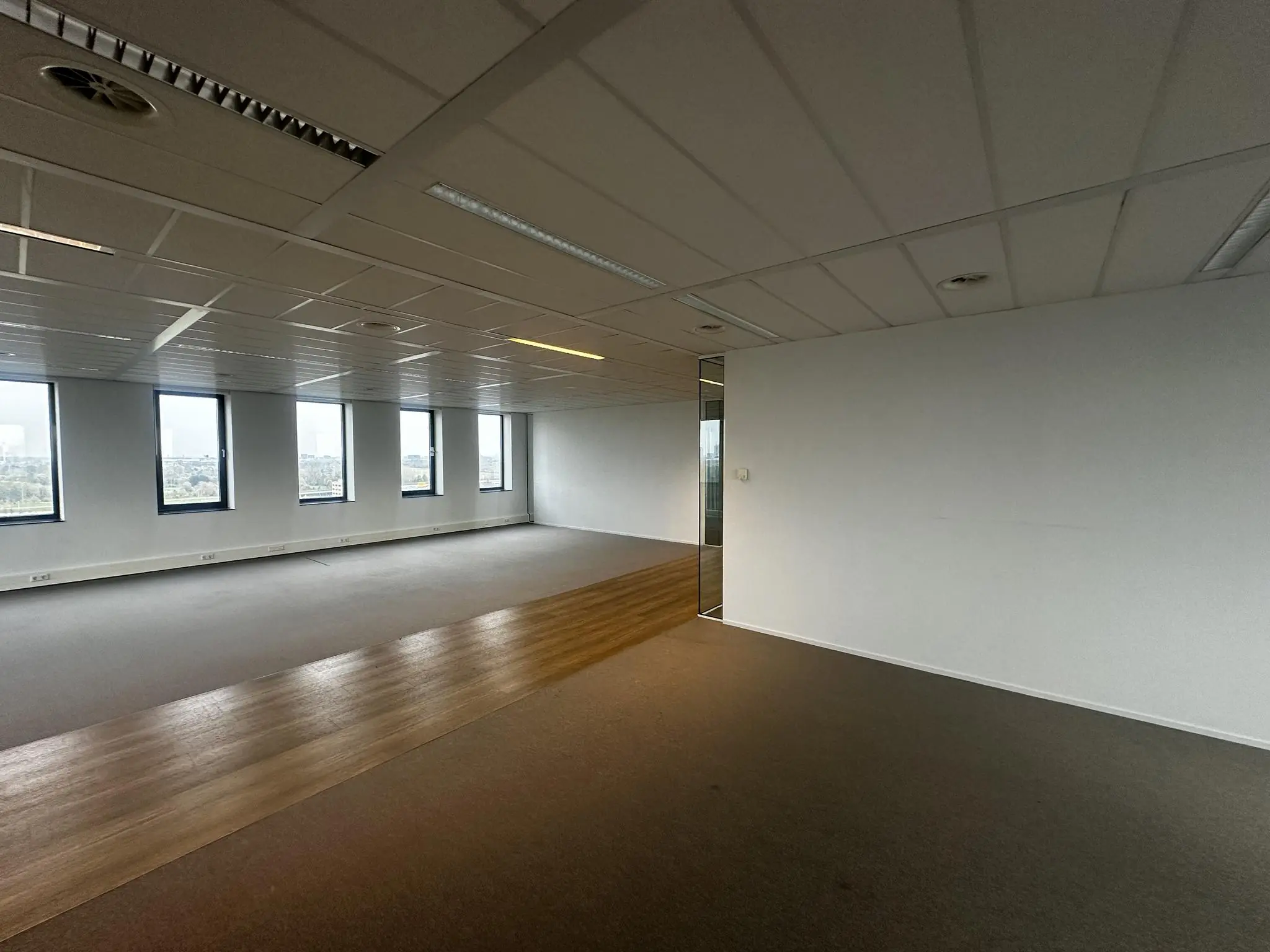 Lege kantoorruimte aan de Laan van Zuid Hoorn met grote ramen en systeemplafond.